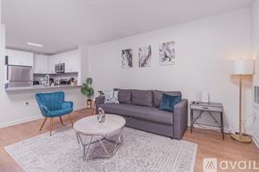 Tysons apartment for rent - A living room with a grey couch, a blue chair, and a coffee table.