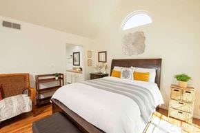 Los Angeles condo for rent - A bedroom with a large bed and a chair.