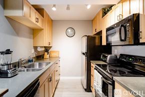 San Diego condo for rent - A kitchen with wooden cabinets and black appliances.