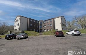 St. Cloud apartment for rent - A parking lot with cars and a building in the background.