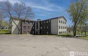 St. Cloud apartment for rent - A large, multi-story building with a parking lot in front.