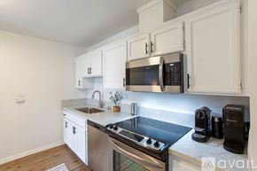 San Diego condo for rent - A kitchen with white cabinets and a stainless steel stove top.