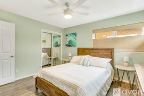 San Diego house for rent - A bedroom with a bed, a ceiling fan, and a nightstand with a lamp.