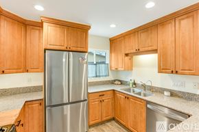 San Diego house for rent - A kitchen with wooden cabinets and a stainless steel refrigerator.