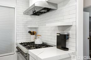 Imperial Beach condo for rent - A modern kitchen with a white tiled backsplash and a white stove top.