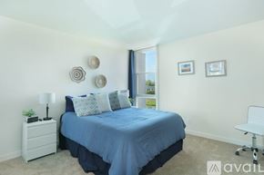 San Diego condo for rent - A bedroom with a blue bedspread and a white chair.