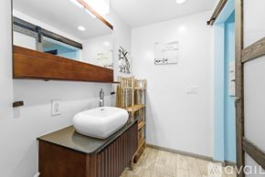 San Diego apartment for rent - A kitchen area with a refrigerator, microwave, and a table with a red stool.