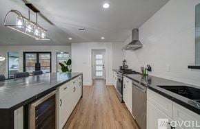 Houston house for rent - A modern kitchen with a long counter and a stainless steel dishwasher.