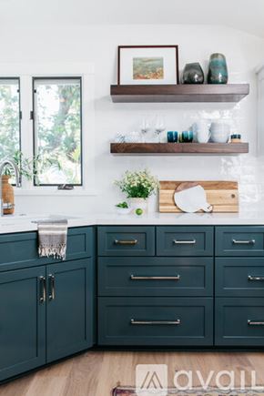 Laguna Beach house for rent - A kitchen with dark green cabinets and a white countertop.