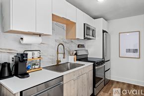 Dallas apartment for rent - A kitchen with white cabinets and a marble backsplash.