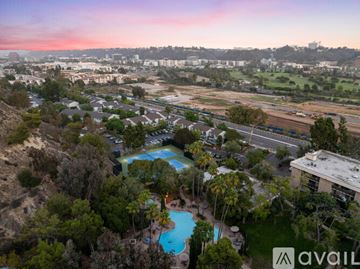 San Diego condo for rent - A living room with a grey couch, a brown chair, a coffee table, and a painting on the wall.