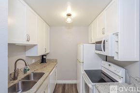San Diego condo for rent - A kitchen with white cabinets and a granite countertop.