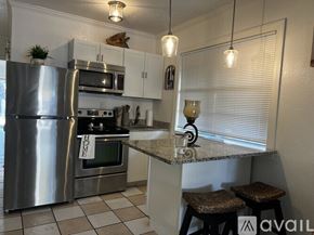 Tampa apartment for rent - A kitchen with a stainless steel refrigerator, microwave, and oven.