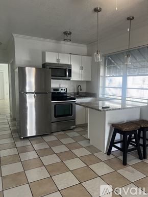 Tampa apartment for rent - A kitchen with a checkered floor and a stainless steel refrigerator.