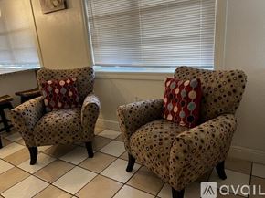 Tampa apartment for rent - Two chairs with red and white pillows are in front of a window.
