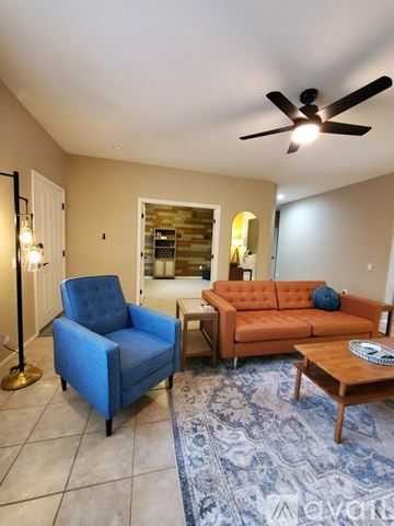 Surprise house for rent - A living room with a blue chair and an orange couch.