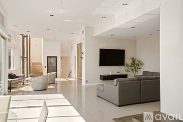 West Hollywood apartment for rent - A spacious living room with a fireplace and a painting on the wall.