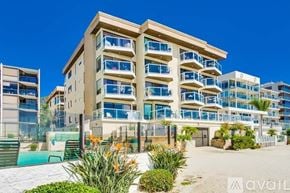 San Diego condo for rent - A modern multi-story building with balconies and a pool in the foreground.