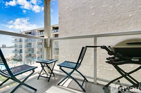 San Diego condo for rent - A balcony with a table and chairs overlooking a building.