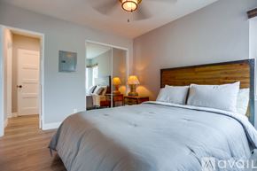 San Diego apartment for rent - A bedroom with a large bed and a wooden headboard.