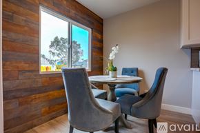 San Diego apartment for rent - A dining room with a wooden wall and a table with chairs.