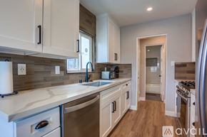 San Diego apartment for rent - A kitchen with white cabinets and a marble countertop.