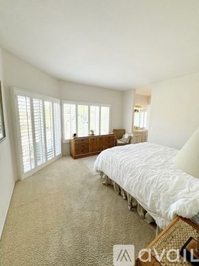 San Marcos condo for rent - A bedroom with a large bed and a dresser with a mirror.