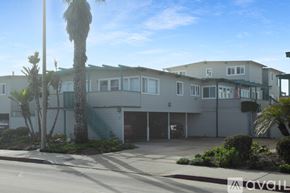 Imperial Beach condo for rent - A building with a palm tree in front of it.