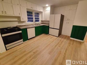 Atlanta house for rent - A kitchen with white cabinets and green backsplash.