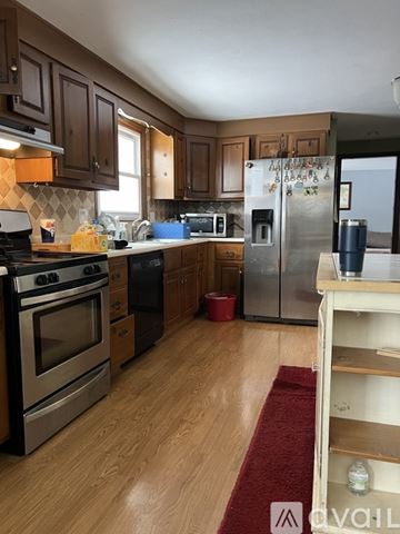 Liverpool apartment for rent - A kitchen with wooden cabinets and a stainless steel refrigerator.