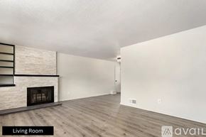 Pueblo house for rent - A living room with a fireplace and wooden floors.