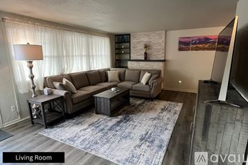 Pueblo house for rent - A living room with a grey sofa, a table with a lamp and a painting on the wall.