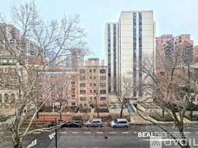 Chicago apartment for rent - A view of a city street with cars and buildings.