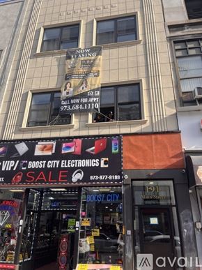 Paterson apartment for rent - A storefront with a sign that says "Boost City Electronics" and a phone number below it.