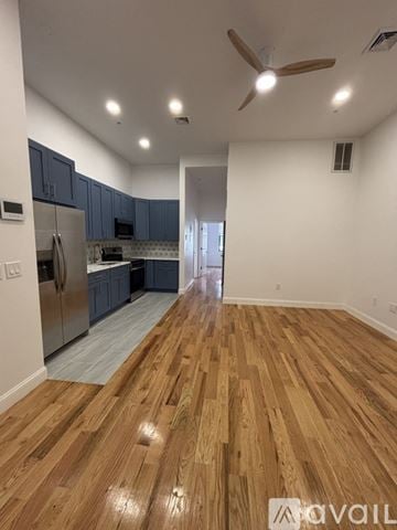 Paterson apartment for rent - A kitchen with wooden floors and a refrigerator.