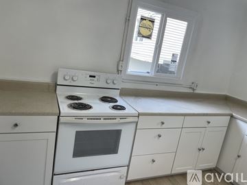 Seattle apartment for rent - A white kitchen with a stove and cabinets.