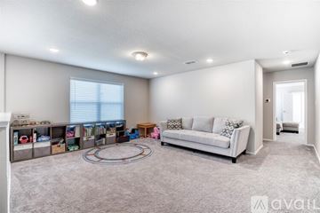 Denton County apartment for rent - A spacious living room with a white sofa and a grey carpet.