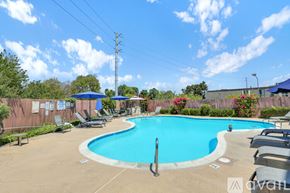 San Diego condo for rent - A pool with a blue umbrella and chairs around it.