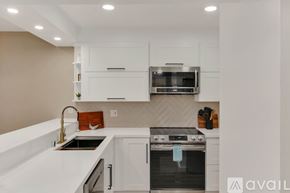 San Diego condo for rent - A modern kitchen with a stainless steel oven and white cabinets.