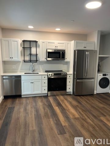 Enfield apartment for rent - A kitchen with white cabinets and a wooden floor.