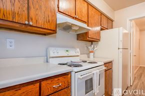 Suffolk apartment for rent - A kitchen with wooden cabinets and white appliances.
