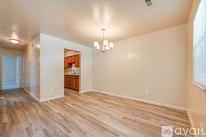 Suffolk apartment for rent - A spacious room with wooden flooring and a chandelier.