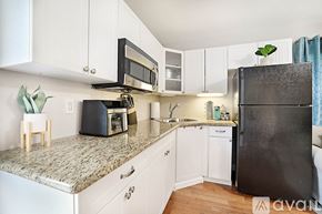 West Palm Beach apartment for rent - A kitchen with a black refrigerator and white cabinets.