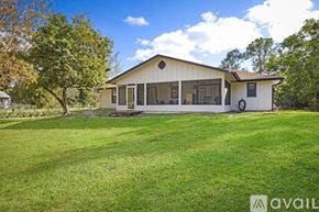 West Palm Beach apartment for rent - A house with a white exterior and a large lawn in front.