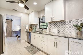 West Palm Beach apartment for rent - A kitchen with white cabinets and a tile backsplash.