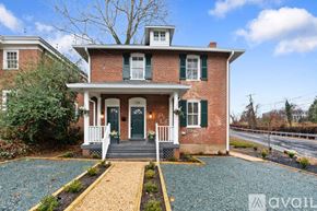 Charlottesville apartment for rent - A red brick house with a green door and a porch.