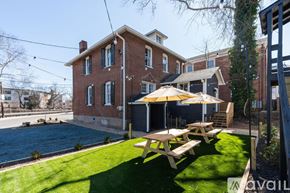 Charlottesville apartment for rent - A house with a red brick exterior and a green lawn.