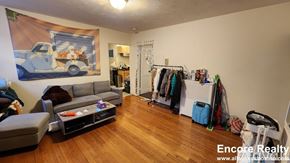 Boston apartment for rent - A room with a painting of a truck on the wall and a grey sofa.