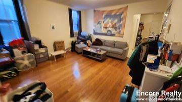 Boston apartment for rent - A living room with a grey couch and a painting on the wall.