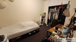 Boston apartment for rent - A bedroom with a bed, a table, and a closet.
